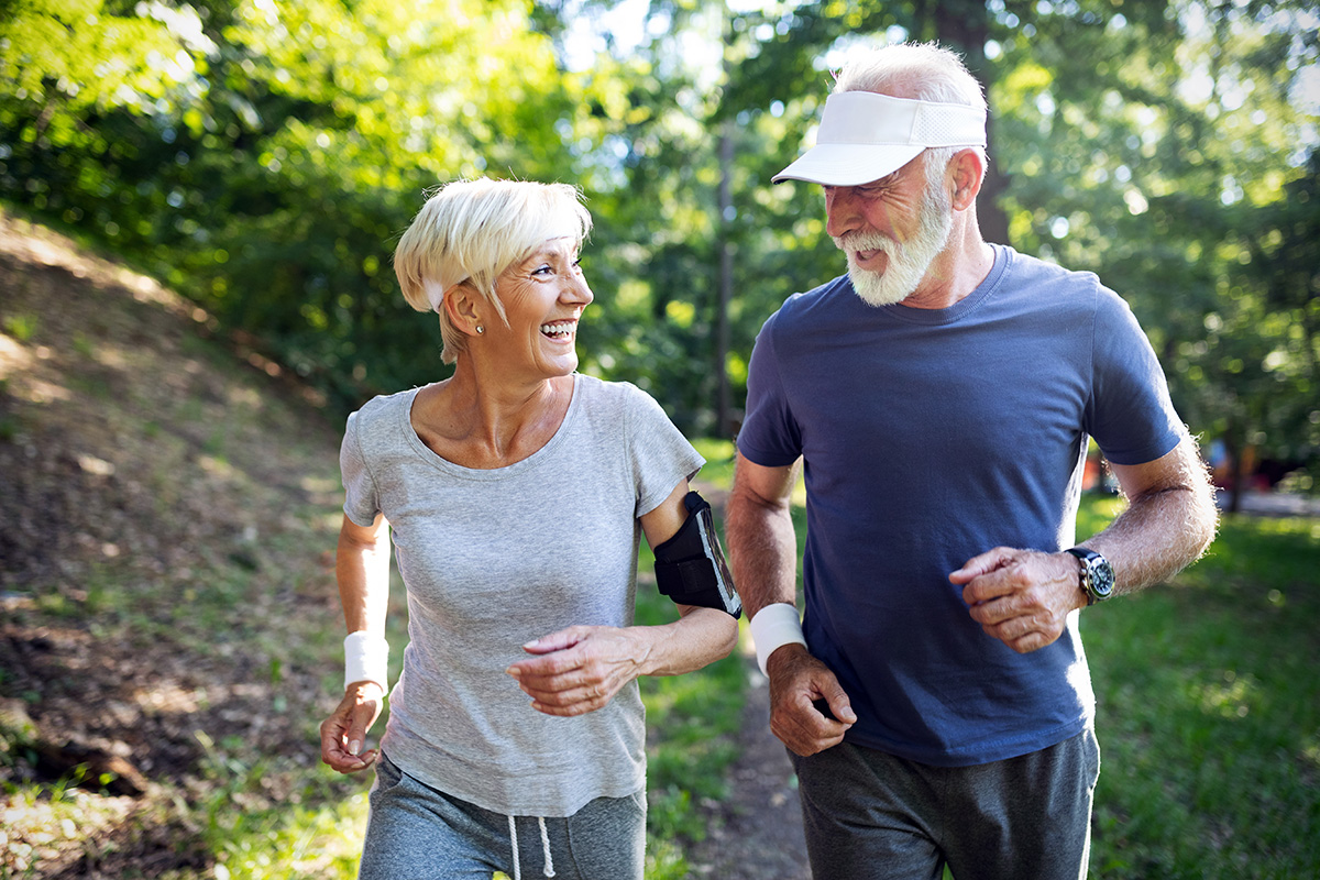 Happy fit senior couple exercising in park